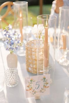 the table is set with candles and place cards