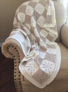 a white crocheted blanket sitting on top of a chair