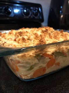 a casserole dish with carrots and meat in it on a counter top