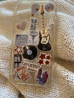 an iphone case with various stickers and magnets attached to it on a blanket