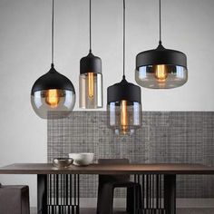 three lights hanging from the ceiling above a table