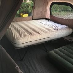 the inside of a camper van with a bed and air mattresses in it