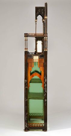 an ornate wooden clock with green and gold accents