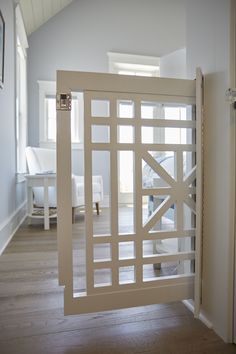 an open door in the middle of a room with wood flooring and white walls