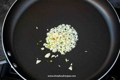 onions being cooked in a frying pan on top of the stove with oil and seasonings