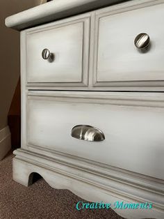 a white dresser sitting in a bedroom next to a window