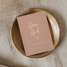 a pink book with the words dear god on it sitting on top of a plate