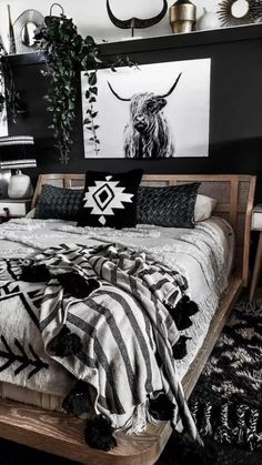 a bed with black and white decor on the wall next to two planters in front of it