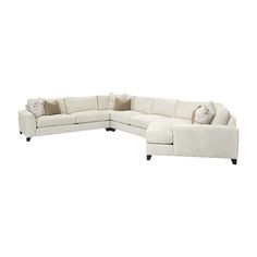 a large sectional couch with pillows on it's back and side facing the camera