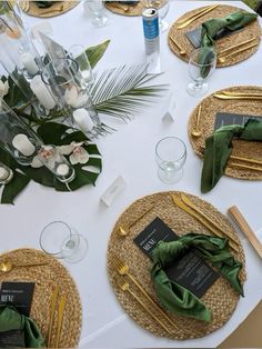 the table is set with place settings, napkins, and flowers in vases