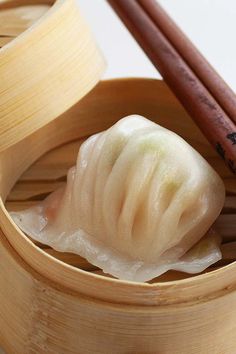 dumplings in a bamboo steamer with chopsticks