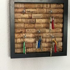 a cork bulletin board with keys hanging from it's sides and two key holders on each side