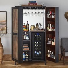 an open cabinet with wine glasses and liquor bottles on it in a living room area