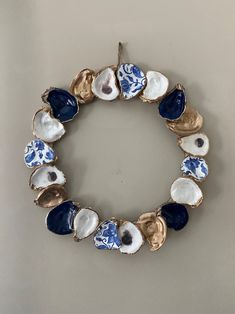 a blue and white bracelet with seashells hanging from it's center loop