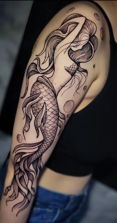 a woman's arm with a fish tattoo on the left side of her body