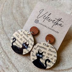 a pair of earrings with black cats on them