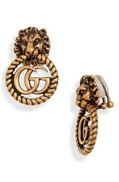 Clip-on earrings feature a Double-G pendant protected within the powerful jaws of a majestic lion—blending two of the house's emblematic symbols. An aged golden finish completes its royal heirloom quality. 1 1/2" drop; 1" width Clip-on style Goldtone plate Made in Italy Cropped Button Up Shirt, Majestic Lion, Best Clips, Hammered Earrings, Traditional Earrings, Diamond Eyes, Chanel Earrings, Stud Set, Stone Studs