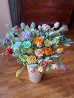 a vase filled with colorful flowers on top of a wooden table