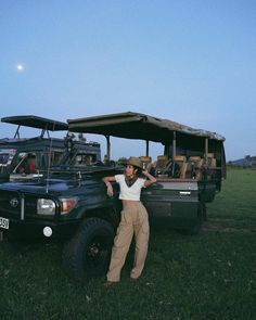 a man standing next to a truck in the grass