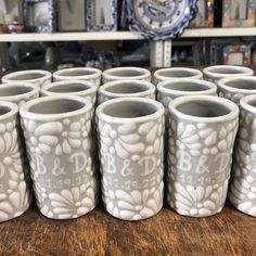 six white cups sitting on top of a wooden table