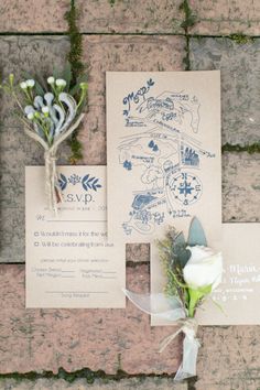 the wedding stationery is laid out on top of the stone wall, and flowers are tied to it