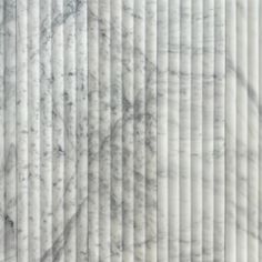 white marble textured wall with vertical lines in the center and diagonals on each side