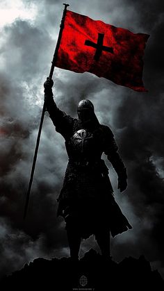 a man holding a red flag on top of a hill