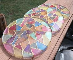 two colorful plates sitting on top of a wooden table