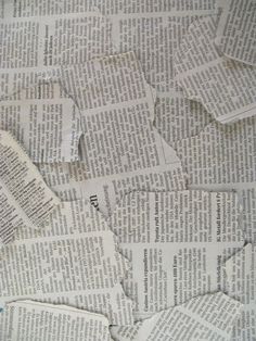 a pile of torn newspaper sitting on top of a table