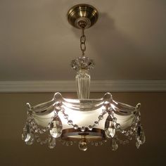 a chandelier hanging from the ceiling in a room with beige walls and white trim