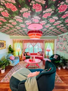 the living room is decorated in pink, blue and green with flowers on the ceiling