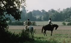 two people riding horses in a field