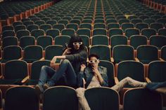 a man sitting in an empty auditorium with his feet on the ground