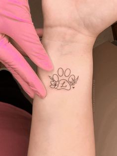 a small paw tattoo on the wrist