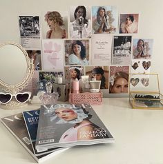 a table topped with magazines and glasses next to a mirror