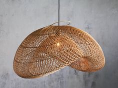 a wooden light hanging from a ceiling in a room with concrete walls and flooring