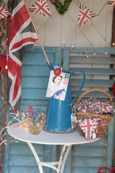 a blue watering can sitting on top of a table next to a flag and other decorations