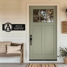 the front door to a home with a bench and potted plant next to it