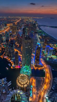 an aerial view of the city lights and buildings at night in abu, united arab emirates