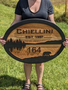 a woman holding up a wooden sign that says, chellini est 19094