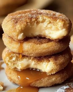 three doughnuts stacked on top of each other with caramel sauce drizzled over them