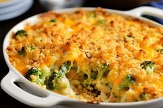 a casserole dish with cheese and broccoli in it on a table