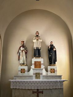 three statues of jesus and mary on top of a church alter