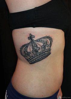 a woman's stomach with a crown tattoo on it