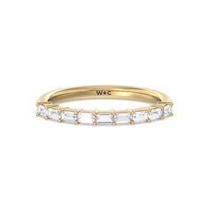 a yellow gold wedding band with baguettes on the side and white diamonds in the middle