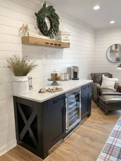 a living room filled with furniture next to a wooden floor and white painted wall behind it