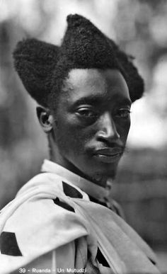 an old black and white photo of a man with a mohawk on his head wearing a dress