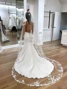 the back of a bride's wedding dress is shown in front of a mirror