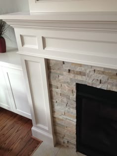 a fireplace with white mantles and wood floors