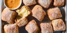 a tray filled with pastries and dipping sauce